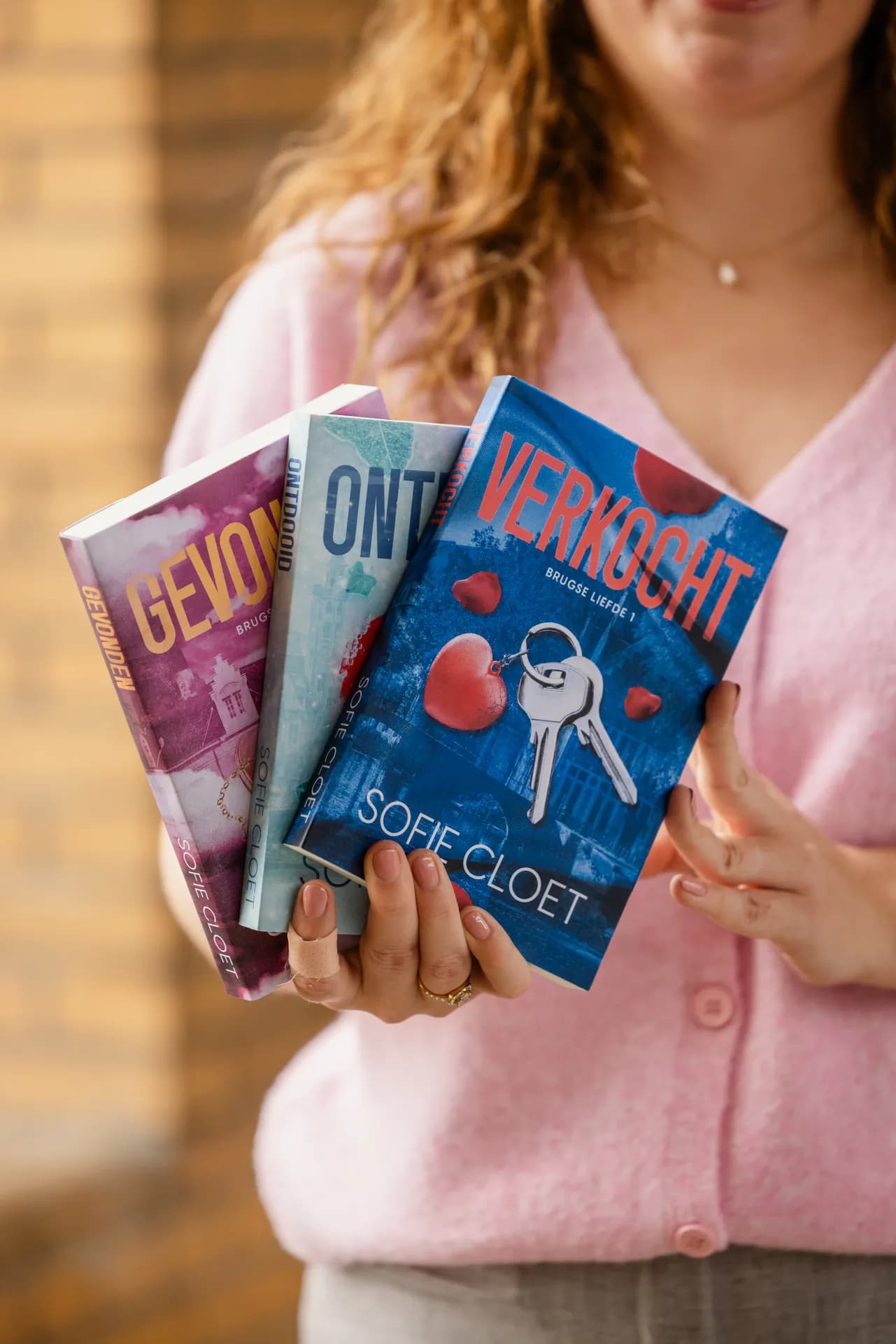 Auteur Sofie Cloet met haar romanceboeken uit de reeks Brugse Liefde..